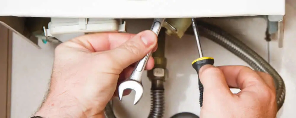 Boiler repair technician tightening pipe fittings and connections in Cape Coral, FL