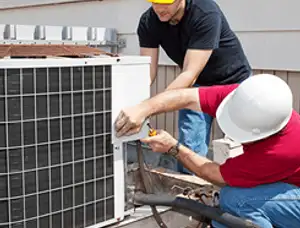 HVAC technicians repairing an outdoor AC unit on a rooftop in Cape Coral, FL