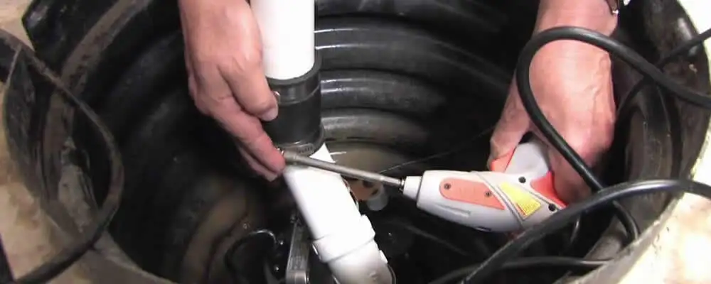 Sump pump installation technician connecting PVC discharge piping in Cape Coral, FL