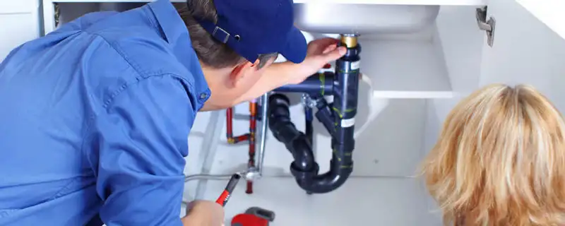 Plumber repairing under-sink drain pipes and fittings in Cape Coral, FL
